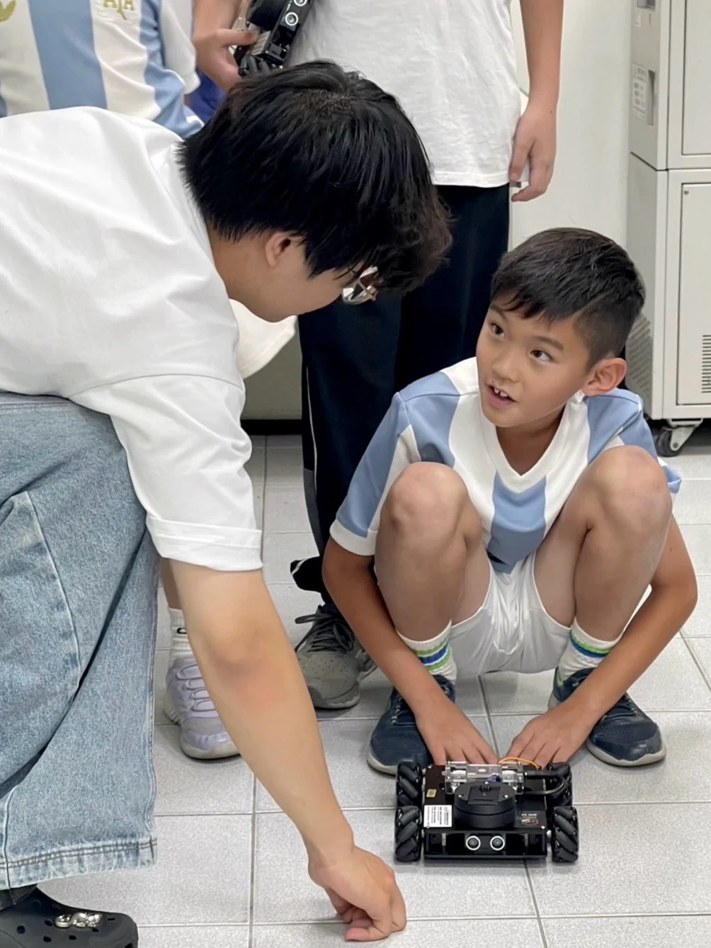 老師在旁協助孩子調整自走車